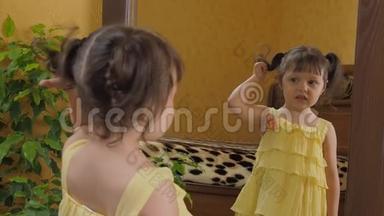 小女孩在镜子前扭尾巴。 一个头上有尾巴的漂亮女孩看着猫头鹰的倒影。 一杯